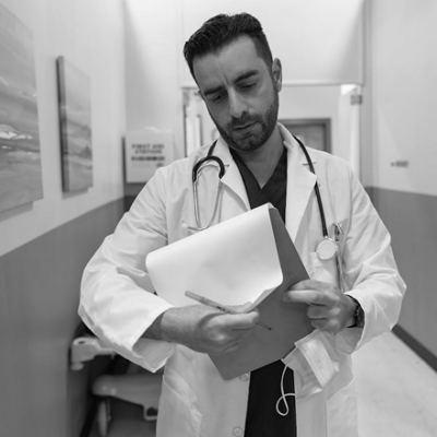 Doctor reviewing patient charts in hospital hallway